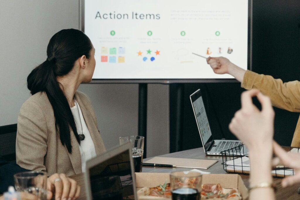 Colleagues discussing a presentation of action items in an office setting.
